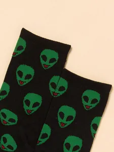 Close-up of black crew socks featuring a vibrant green alien head pattern detail