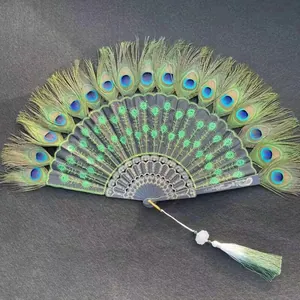 Close-up of a peacock feather folding fan with green floral embroidery and tassel