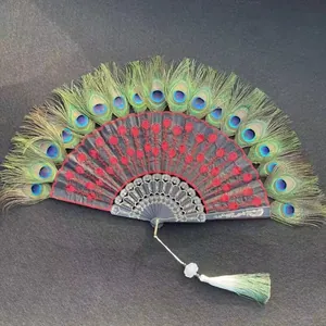 Detailed view of peacock feather folding fan with red floral embroidery and sequins