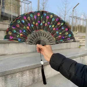 Close-up of a black Chinese folding fan with colorful peacock feather embroidery.