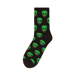 Black crew socks for men featuring a repeating green alien head pattern with tongue out