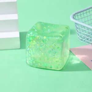 Detail shot of a green translucent cube squishy toy with shimmering glitters inside