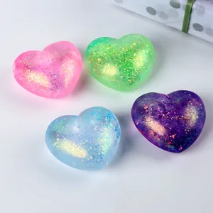 Macro view of four colorful glitter heart-shaped squishy toys with a slow-rebound texture.