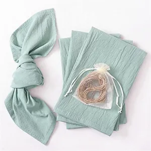 Detail of soft sage green cotton linen gauze napkins with decorative hemp rope set