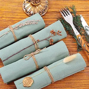 Macro detail of sage green cotton linen napkins tied with rustic twine decor