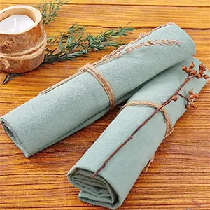Close-up of mint green cotton linen napkins with rustic twine and dried flower detail