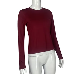 Close-up of slim-fit wine red long-sleeve top for women on white mannequin.