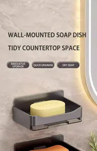 Close-up detail of grey wall-mounted soap dish with drainage tray and yellow soap bar