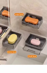 Detail of wall-mounted soap dish set showing different soap sizes in gray draining holders