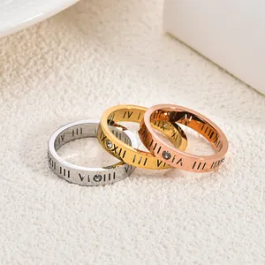 Gros plan de trois bagues avec chiffres romains en argent, or et or rose avec cristaux.