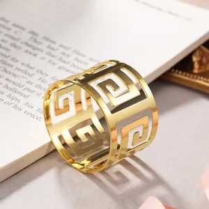 Macro view of gold hollow metal napkin ring with geometric Greek key pattern