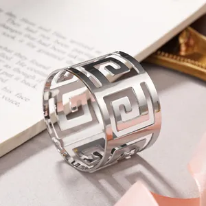 Close-up detail of silver hollow metal napkin ring with elegant Greek key pattern