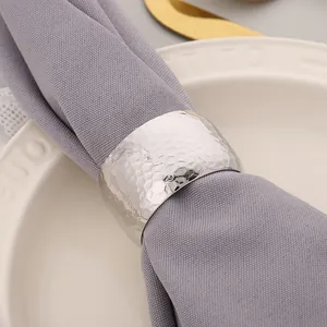 Detail of premium silver hammered texture metal napkin ring on elegant gray fabric napkin