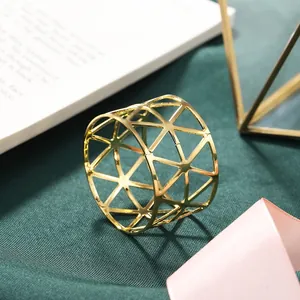 Elegant golden hollow metal napkin ring with triangular geometric pattern for table decor.