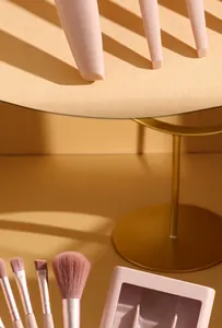 Close-up detail of the 5-piece portable pink makeup brush set with its mirror storage box