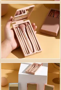 Detailed view of a portable five-piece makeup brush set in a pink mirrored case.