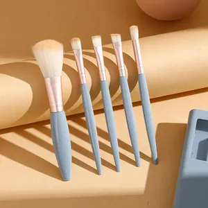 Detailed view of five professional makeup brushes featuring grey handles and rose gold ferrules