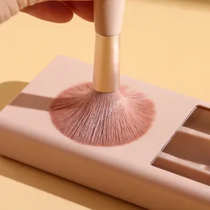 Detailed close-up showing the soft pink bristles of a portable mini makeup brush