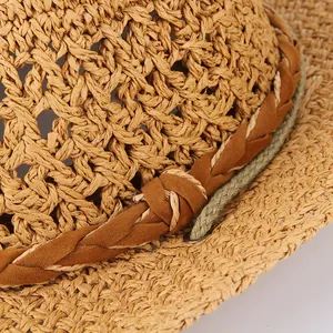 Dettaglio ravvicinato di un cappello di paglia cowboy estivo con fascia marrone intrecciata