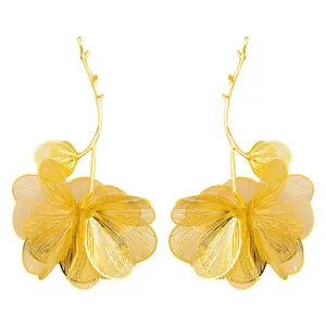 Detailed view of gold oversized hollow flower drop earrings with branch stems