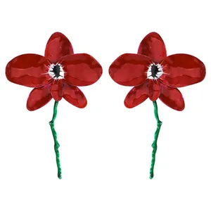 Detailed macro view of vibrant red 3D orchid flower drop earrings with long green stems