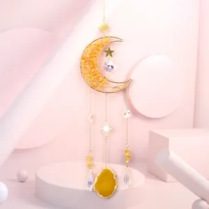Detailed macro view of a golden moon suncatcher with yellow agate slice and faceted crystals