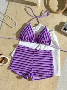 Detailed flat lay of purple striped terry cloth bikini set with beach accessories