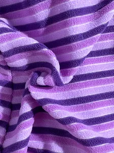 Detailed close-up view of purple striped terry cloth fabric for soft bikini texture.