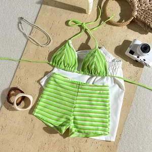Flat lay of striped lime green terry cloth bikini set with beach accessories