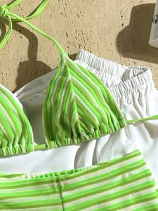 Close-up detail of a lime green striped terry cloth bikini set with soft towel texture