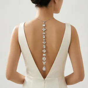 Gros plan d'un collier de dos étincelant en strass sur une robe de mariée blanche.