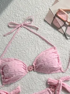 Close-up of pink bikini top featuring a unique floral texture and flower buckle