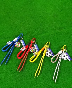 Close-up detail of colorful braided soccer ball keychains on green turf background