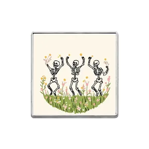 Close-up of square brooch featuring three dancing skeletons in a flower field.