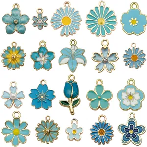 Lot de 30 breloques fleurs en émail bleu et blanc de formes variées pour bijoux DIY.