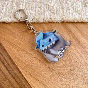 Cute blue shark acrylic keychain charm with funny character design on wooden surface