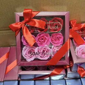 Detailed view of nine pink rose soap flowers in a gift box with a red ribbon bow