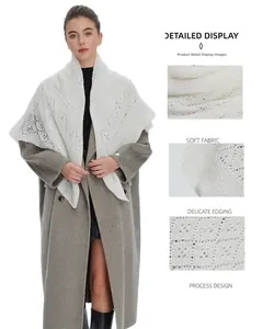 Detail view showing the soft fabric and hollow-out patterns of the white knitted shawl.