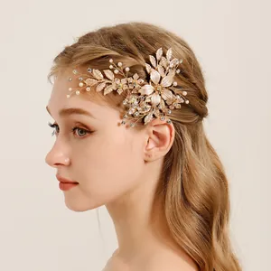Detailed view of a gold bridal flower hair clip with pearls worn by a female model.
