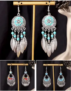 Detailed showcase of Bohemian vintage silver-tone tassel earrings with turquoise beads and feathers