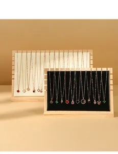 Two wooden jewelry display stands with velvet cushions showing multiple necklaces