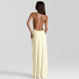 Back view of an elegant cream yellow backless halter maxi dress with gathered details