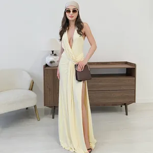 Elegant deep V-neck halter dress with ruched details and high slit, shown on model.