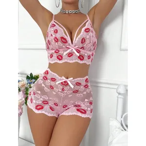 Detaillierte Ansicht des rosa Spitzen-Lingerie-Sets mit feiner roter Lippenbestickung.