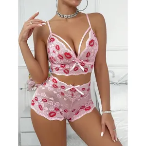 Sexy rosa Spitzenunterwäsche-Set mit roter Lippenbestickung und Schleifendetails.