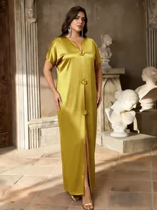 Close-up detail of luxury gold satin maxi dress with 3D floral buttons and split