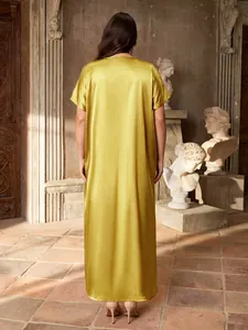 Back view of an elegant gold satin long dress with short sleeves in a classical setting
