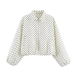 Gros plan d'une veste à pois pour femme avec fermeture éclair et poignets élastiques.