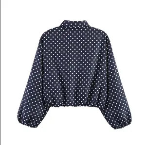 Vue arrière d'une veste courte bleu marine élégante avec pois blancs et ourlet élastique