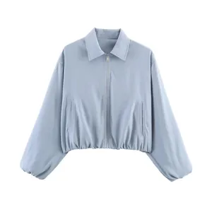 Détail d'une veste zippée courte bleu clair avec un ourlet élastique ajusté.